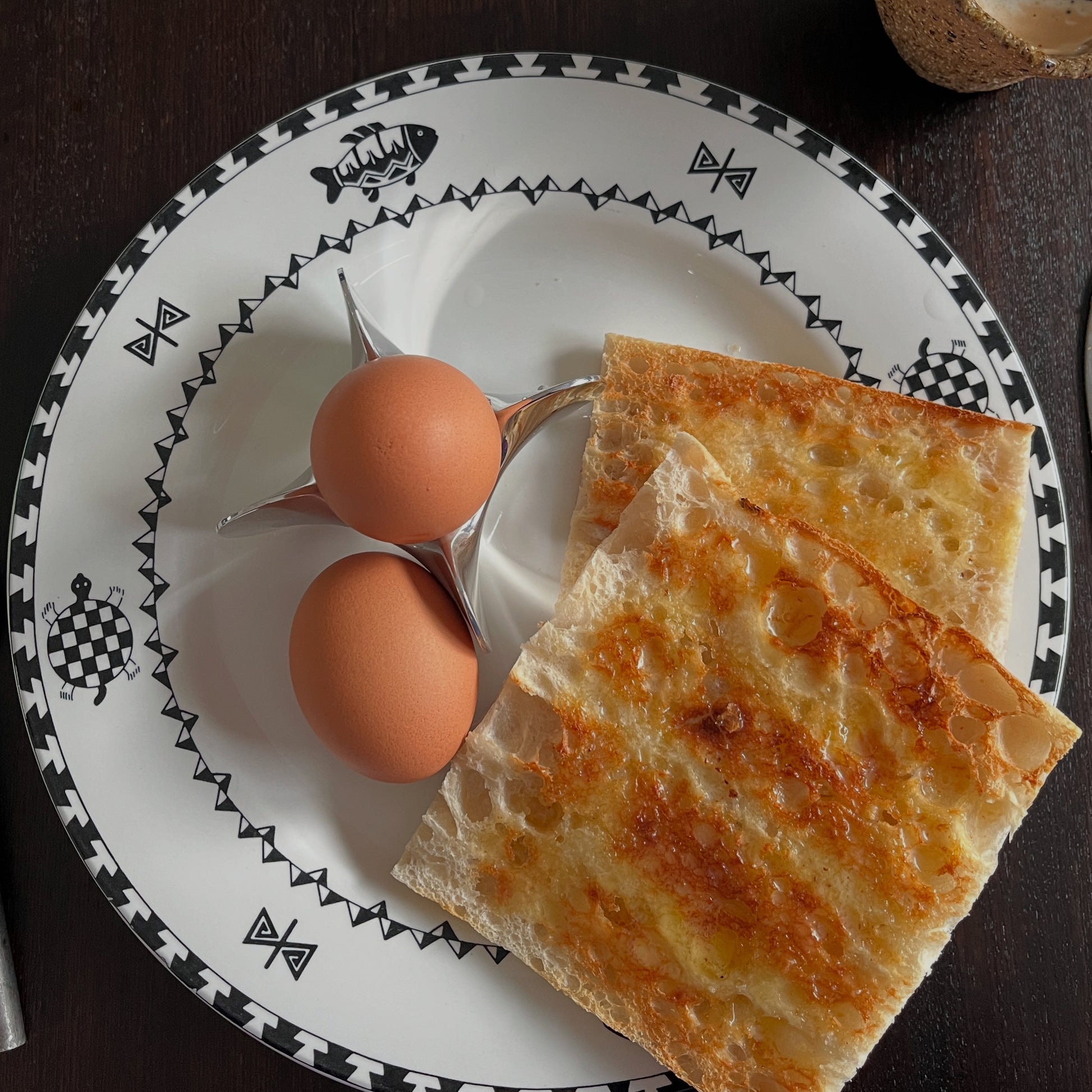 Two eggs on a plate with two slices of toast.