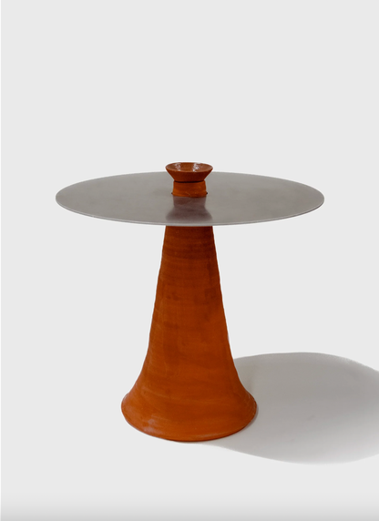 Table with a round top and conical base on a white background